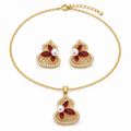 Gold lotus jewelry set on white — pendant necklace and stud earrings in red enamel with freshwater pearls and zirconia